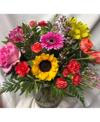 A NEW DAY ARRANGEMENT…Bright pink orange  Yellow flowers arranged in a vase with filler. Some flowers may change according to availability.
