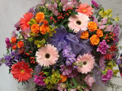BRIGHT MEMORIES    (CS) Half Casket Spray of Lavenders, oranges, pinks and lime greens. Spray roses, gerbera daisies, carnations, button poms and berries
