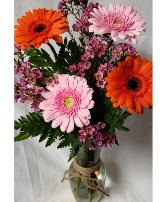 Gerbera Brights...different colored gerberas (E) in a vase with filler (seasonal) gerbera colors may vary