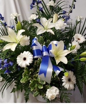 BLUE AND WHITE SEASONAL  (S) flowers with a blue and white Bow.