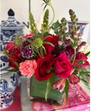 Cube with red roses, carnations and snaps. 