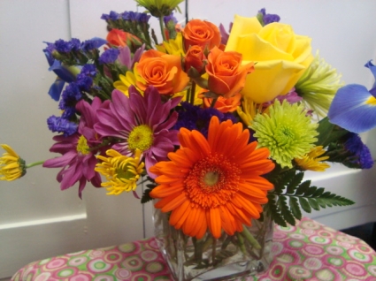 Small bright mixture of seasonal flowers  (E) to take home in a rectangular vase.