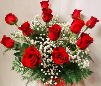 Dozen Red Roses arranged in a vase with  (R) baby's breath.