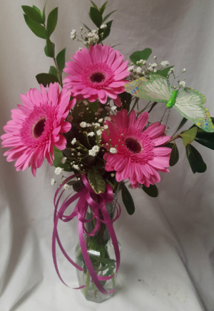 3 PINK GERBERA  DAISIES AND (E) BUTTERFLY IN A BUD VASE. (GERBERA COULD BE RED, PINK OR WHITE)