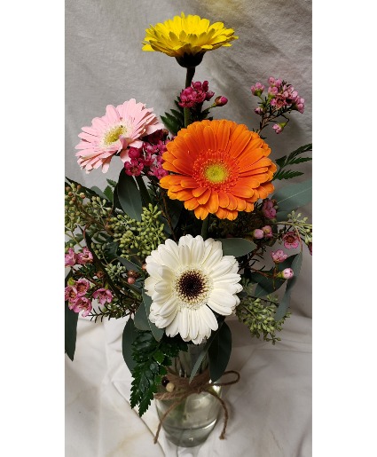 GERBERA BRIGHTS...4 gerbera daisies with filler Arranged in a bud vase...Filler could be baby's breath  or wax...whatever is in stock...seasonal...gerberas could be different colors