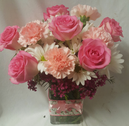 "PINK DELIGHT"...(E)....PINK ROSES, PINK Carnations and white daisies  OR white cushions  with filler arranged in a cute ribbon detailed rectangular vase! (rose color may vary light or med pink)