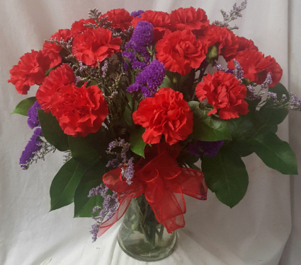 DOZEN RED CARNATIONS WITH (E) PURPLE STATUS ARRANGED in a vase!