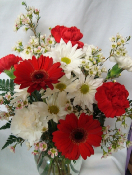 Miami colors! Red and white flowers  (E) arranged in a vase.