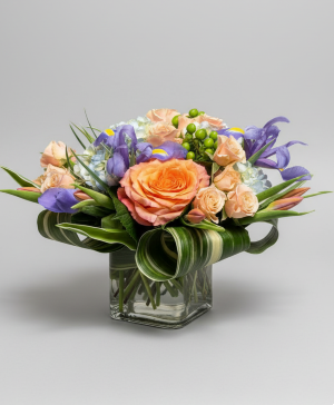 Lively Spring Vased Arrangement using Iris, Tulips, Roses, & Hydrangea.