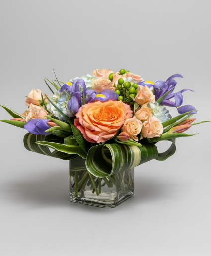 Lively Spring Vased Arrangement using Iris, Tulips, Roses, & Hydrangea.
