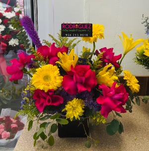 Mix colorful arrangement in a cube vase gerber daysies, roses, cushon, lilys, etc.