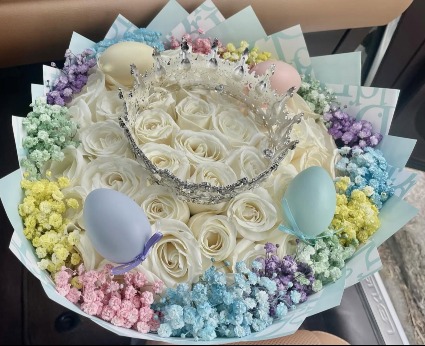 #7 Easter Bouquet 50 white roses bouquet with baby breath around, a crown, and plastic easter eggs