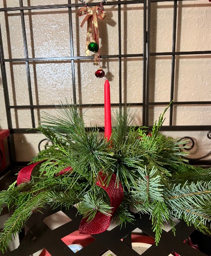 Round centerpiece  Fresh holiday greens with  a single  candle round 