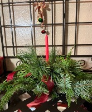 Round centerpiece  Fresh holiday greens with  a single  candle round