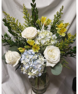 "SHINING BRIGHT" BLUE HYDRANGEAS, YELLOW (F) Lilies,white roses, solidaster arranged in a vase. 