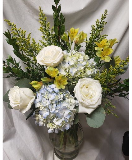 "SHINING BRIGHT" BLUE HYDRANGEAS, YELLOW (F) Lilies,white roses, solidaster arranged in a vase. 