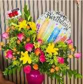 Sunrise Arrangement Arrangement in a vase made of hot pink roses, yellow lilys, orange mini spray roses, solidago, etc. * Ballon is included