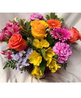 TROPICAL SUMMER…pink roses orange roses  Pink and orange gerbera daisies yellow flowers all arranged in vase. We will use colors but they may vary with availability.