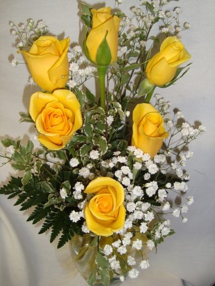 (R) Six Bright Yellow  Roses with seasonal  filler arranged in a vase.