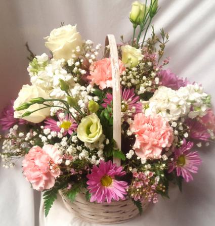 Wicker Basket filled with seasonal   (S) pimks, white,and lavenders to take home after the services.