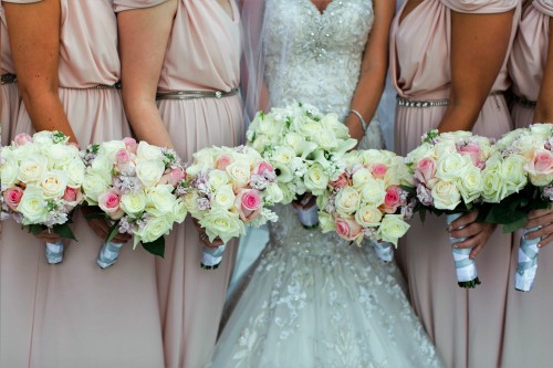 Photo of bridesmaid holding bridal bouquets